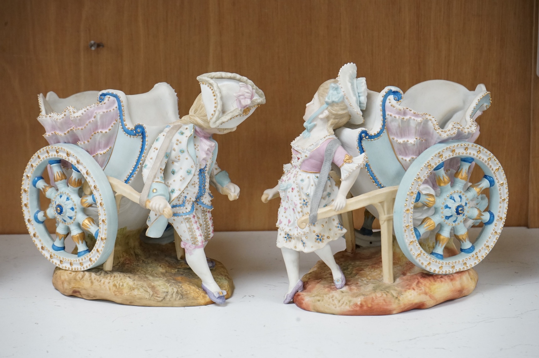 A pair of French coloured biscuit porcelain carriage group centre pieces, 21cm wide
